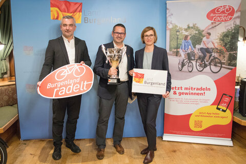 Landesrat Heinrich Dorner und Christine Zopf-Renner, Leiterin Mobilitätszentrale Burgenland, gratulierten Bürgermeister Ernst Edelmann, der einen Wanderpokal, einen Burgenland-Gutschein im Wert von 100 Euro und ein Funktionsshirt überreicht bekam.