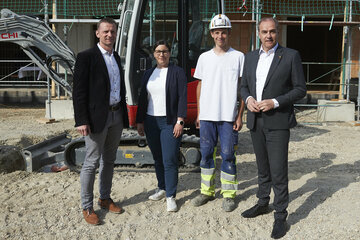 Klaus Tremmel, technischer Niederlassungsleiter Hochbau PORR Bau, SOWO-Geschäftsführerin Melanie Piskernik, und Landesrat Dr. Leonhard Schneemann mit dem stolzen Lehrling, der den Gleichenspruch vortrug, bei der Gleichenfeier.