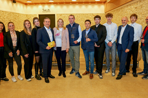 Bildungslandesrätin Mag.a (FH) Daniela Winkler (6.v.l.) mit Direktor Professor Mag. Hannes Nitschinger (5.v.l.), Obmann Herbert Oschep (Wein Burgenland) (7.v.r.) sowie Initiator Heinz Josef Zitz (3.v.r.) sowie weiteren beteiligten Lehrern und Schülerinnen und Schülern am Ausbildungsschwerpunkt der BHAK-BHAS Neusiedl am See.