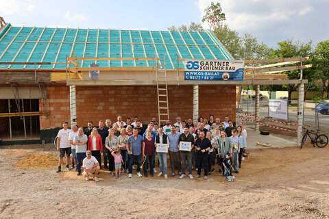 Landesrätin Daniela Winkler (5.v.l., stehend) und Bürgermeister Philipp Pelzer mit allen Beteiligten sowie Musikerinnen und Musikern vor dem Neubau des Musikheimes Andau.