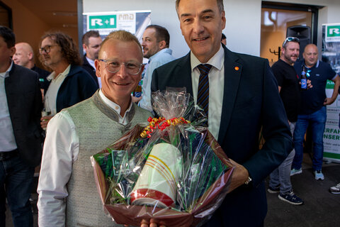 Wirtschaftslandesrat Dr. Leonhard Schneemann überreichte Geschäftsführer Dipl.-Ing. (FH) Markus Frühwirth (v.r.) einen Geschenkskorb.