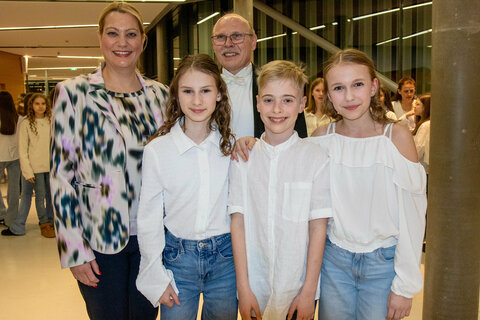 Landesrätin Mag.a (FH) Daniela Winkler mit Dirigent und Projektleiter Anton Gabmayer sowie Schülerinnen und Schülern des schulübergreifenden Projektchors.