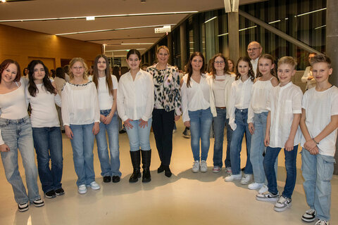 Landesrätin Mag.a (FH) Daniela Winkler mit Dirigent und Projektleiter Anton Gabmayer sowie Schülerinnen und Schülern des schulübergreifenden Projektchors.