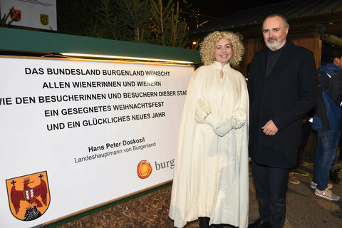 Landeshauptmann Hans Peter Doskozil und das Christkind vor der Burgenland-Tafel am Wiener Rathausplatz