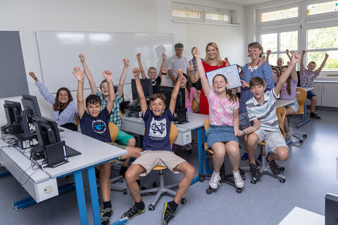 Bildungslandesrätin Daniela Winkler freut sich mit Werner Zwickl (SQM Neusiedl am See), Isabell Lichtenberger, Direktorin MS Kitttsee, und Schülerinnen und Schüler über die Auszeichnung