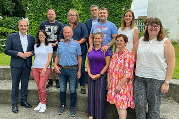 Landesrat Leonhard Schneemann (l.) mit den neuen Pflege- und Adoptiveltern.