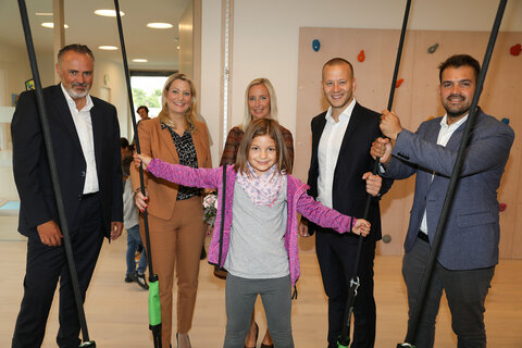 Landeshauptmann Hans Peter Doskozil, Bildungslandesrätin Daniela Winkler, Kindergartenleiterin Christina Michlits (hinten Mitte), NR Maximilian Köllner (2. v.r.) und LAbg. Kilian Brandstätter (1.v.r.) besichtigten mit Sophie im neuen Bewegungsraum im Kindergarten Illmitz