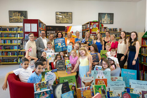 Nina Weiss (Bibliotheksservicestelle), Ernst Edelmann (Bürgermeister), Silke Rois (LVBB), LR Daniela Winkler, Daniela Fidler (Büchereileiterin Gemeindebücherei Wimpassing), Sonja Kaiblinger (Kinderbuchautorin) mit Schüler:innen der VS Wimpassing.