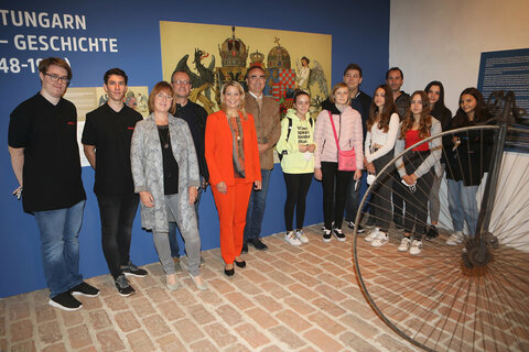 Landesrätin Daniela Winkler, ecole-Direktorin Karin Schneemann, Burgmanager Gilbert Lang und Dieter Szorger, Leiter Hauptreferat Kultur u. Wissenschaft, mit Schülern in der Ausstellung auf Burg Güssing