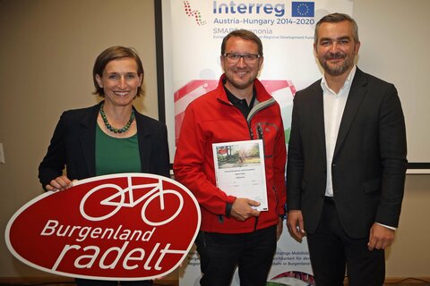 Landesrat Heinrich Dorner und Christine Zopf-Renner überreichten Gilbert Plank (Mitte) einen Gutschein.