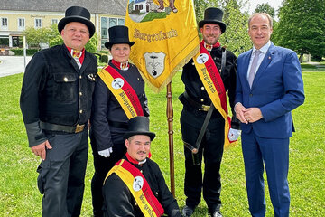 LR Dr. Leonhard Schneemann und Landesinnungsmeister Herbert Baumrock mit neuen Rauchfangkehrermeister*innen und der Innungsfahne.