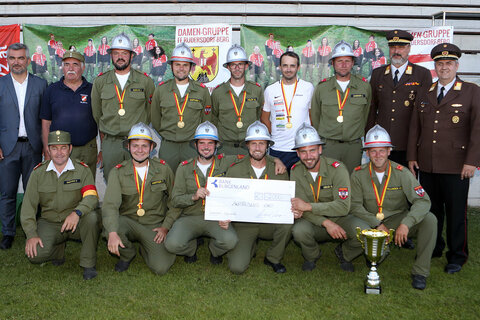 Die Herren der Freiwilligen Feuerwehr Zillingtal erhielten von Landesrat Mag. Heinrich Dorner (l. stehend) und dem Burgenländischen Landesfeuerwehrkomandanten Ing. Franz Kropf (2.v.r. stehend) ebenfalls einen Scheck über 2000 Euro. Auch sie nehmen, so wie die Damen aus Rudersdorf Berg, bei der 17. Feuerwehrolympiade von 17. bis 24. Juli 2022 in Celje, Slowenien, teil.