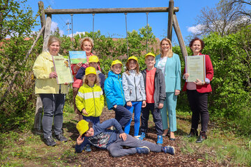 Zertifikat „Naturparkkindergarten“ und „Naturparkschule“ für den Kindergarten und die Volksschule Moschendorf. LRin Mag.a (FH) Daniela Winkler (2.v.r.) und LT-Präs.in Verena Dunst (2.v.l.) mit Kindergartenleiterin Hannelore Gratzer (1.v.l.), Direktorin der VS Moschendorf Claudia Taucher (1.v.r.) und Volksschulkindern