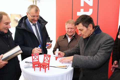 Bei der Grundsteinlegung für das Zentrallagerprojekt des Möbelhauses XXXLutz in Zurndorf wurde eine von Landesrat Christian Illedits in Vertretung von Landeshauptmann Hans Peter Doskozil, Landeshauptmann a.D. Hans Niessl, Landesrätin Mag.a (FH) Daniela Winkler, Landesrat Heinrich Dorner, Landesrat MMag. Alexander Petschnig, Bgm. LAbg. Werner Friedl, XXXLutz Unternehmenssprecher Mag. Thomas Saliger und Dr. Alois Knauseder, Leiter der XXXLutz Bauabteilung, unterzeichnete Urkunde in das Fundament einbetoniert