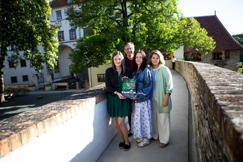 Sophie, Norbert Darabos, Präsident des Österreichischen Friedenszentrums (ACP), Jana und KBB Geschäftsführerin Claudia Priber mit dem Buch „Sichtbar machen. Erinnerungslandschaft – Orte und Zeichen des Gedenkens an die Opfer des Nationalsozialismus im Burgenland“ von Herbert Brettl.