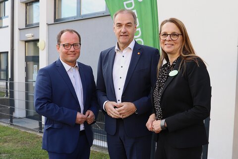 Marek Zeliska, Leiter des SOS-Kinderdorfs Burgenland, Soziallandesrat Leonhard Schneemann und Bernadette Kalcher, pädagogische Leiterin, vor den Räumlichkeiten des neuen Tagesangebots des SOS-Kinderdorfs.