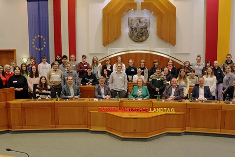 Landtagspräsidentin Verena Dunst (4.v.r. sitzend) mit Klubobmann Johann Tschürtz (2.v.r. sitzend) sowie Auslandsdiener Jonathan Dorner (rechts, sitzend) und den Landtagsabgeordneten Wolfgang Spitzmüller, Patrick Fazekas und Roman Kainrath (sitzend v.l.) mit Professorin Mag. Theres Wiedeschitz, BA und Professor DI (FH) Jürgen Kollmann sowie den Schülerinnen und Schülern der Keramikschule Stoob im Landtagssitzungssaal.