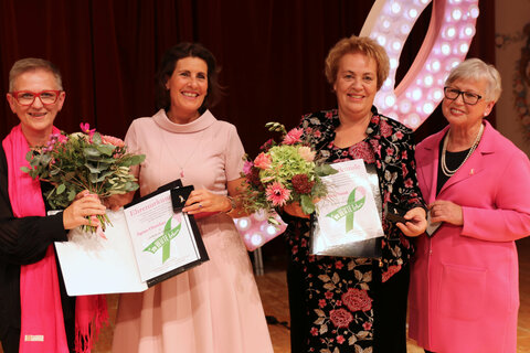 Andrea Pfneiszl (l.) und Irene Zach (r.) von der Selbsthilfegruppe „Im Heute leben“ bedankten sich bei Schirmherrin Ágnes Ottrubay und Landtagspräsidentin Verena Dunst mit einer Ehrenurkunde für deren langjährige Unterstützung der „Pink Ribbon