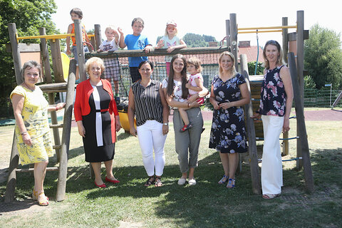 Bürgermeisterin Renate Habetler, Landtagspräsidentin Verena Dunst, Kindergartenpädagoginnen Barbara Frühwirth und Lena Jobst, Landesrätin Mag.a (FH) Daniela Winkler und „Mamas-Küche“-Projektleiterin Erika Gülli mit den Kindern im Garten (v.l.n.r.).