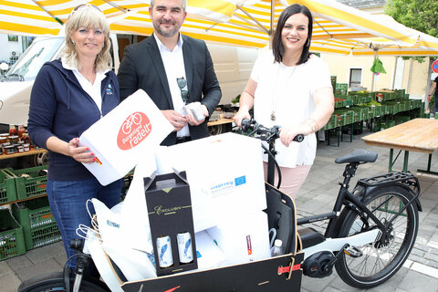 Natur- und Umweltschutzlandesrätin Mag.a Astrid Eisenkopf, Straßenbaulandesrat Mag. Heinrich Dorner, Bürgermeisterin Elisabeth Böhm üben sich im Einkaufen mit einem Lastenfahrrad