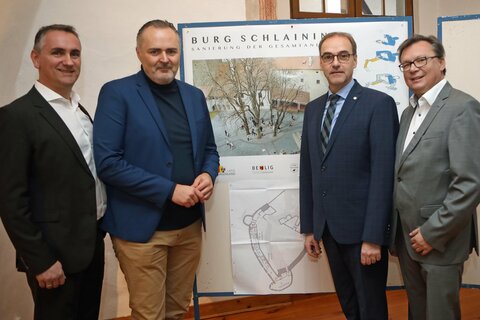 Landeshauptmann Hans Peter Doskozil (2.v.l.) mit Bürgermeister Mag. Markus Szelinger, Dr. Leonhard Schneemann und Mag. Norbert Darabos (v.l.) vor den Plänen der Sanierung der Burg Schlaining.