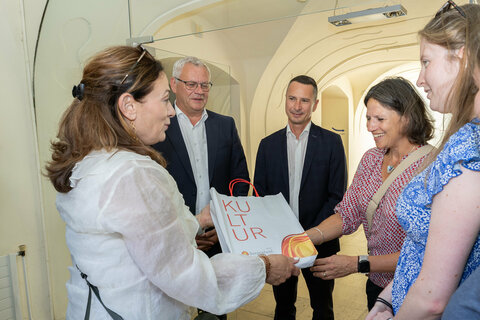 Margit Fröhlich, Leiterin des Referats Landesmuseum, überreicht ein Geschenk an Natalie Barb.