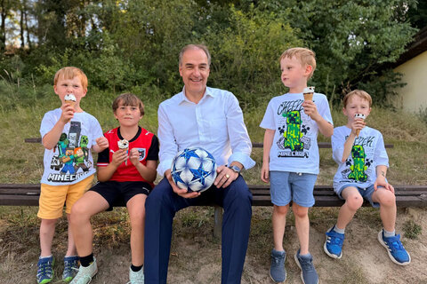 Soziallandesrat Dr. Leonhard Schneemann (Mitte, im Bild mit Kindern).
