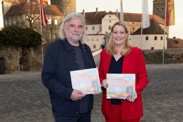 Bildungslandesrätin Mag.a (FH) Daniela Winkler mit Autor Heinz Janisch (v.r.) vor der Burg in Stadtschlaining.
