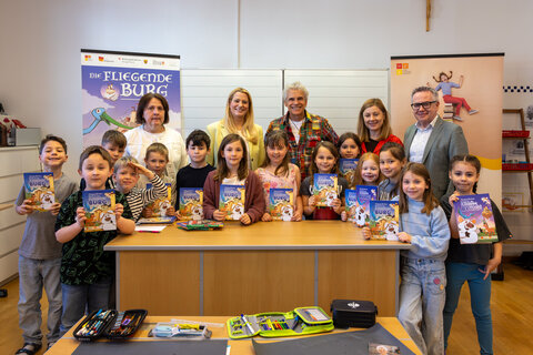 Bildungslandesrätin Daniela Winkler und Thomas Brezina mit Direktorin Karin Eder, dem Lehrerteam und den Kindern der 1. und 2. Klasse der Volksschule Stotzing.
