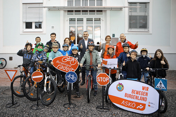 Landesrat Heinrich Dorner (hinten, Mitte) mit Lackenbachs Volksschul-Direktorin Andrea Ecker (3.v.l., hinten), Leiterin Christine Zopf-Renner von der Mobilitätszentrale Burgenland (2.v.r., hinten) sowie ASKÖ Burgenland-Landesgeschäftsführer Andreas Ponic (r., hinten) und ASKÖ Burgenland-Geschäftsführer ASKÖ Fit, Mathias Binder (l., hinten) mit Schülerinnen und Schülern der Volksschule Lackenbach.