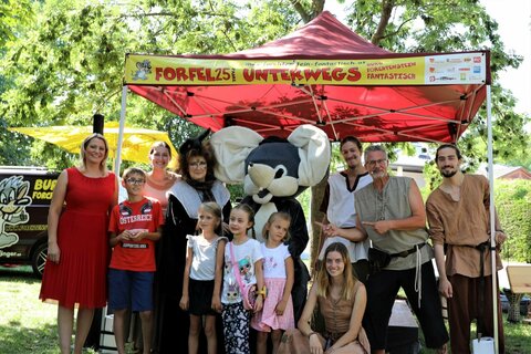 Landesrätin Mag.a (FH) Daniela Winkler (l außen), die Mitwirkenden von „Forfel25 on tour“ sowie begeisterte Kindern als Gäste beim Tourstop in Mönchhof;